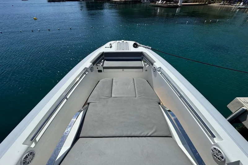 Pirelli 42 Yacht Photos Pics 2021 Pirelli P Zero 42 boat interior with cushioned seating, docked on calm water.