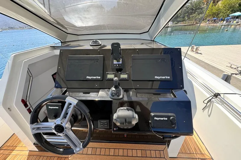 Pirelli 42 Yacht Photos Pics Helm of 2021 Pirelli P Zero 42 boat with Raymarine navigation system, docked by a scenic waterfront.