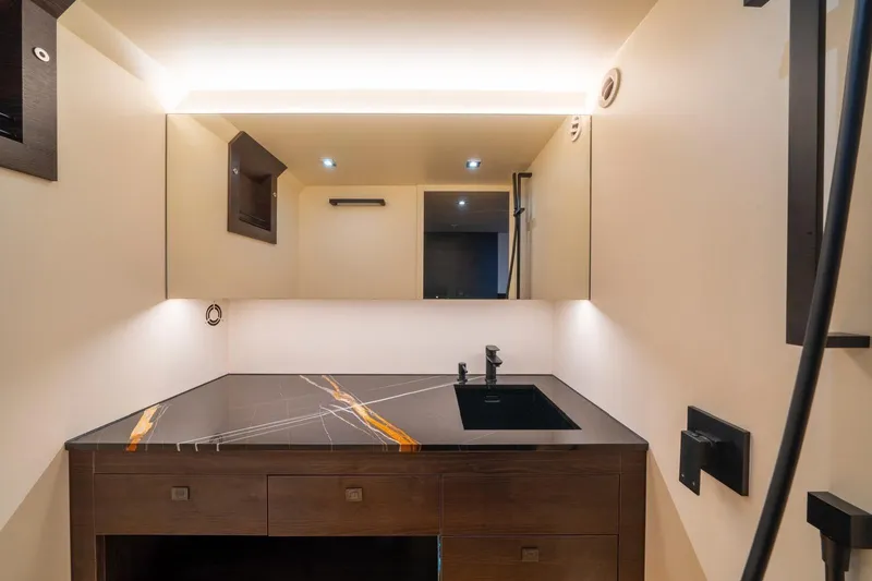 Cobra Yacht Photos Pics Luxurious bathroom interior of 2022 Vanquish Yachts VQ45 with modern sink and lighting.