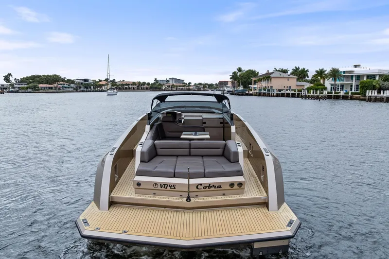 Cobra Yacht Photos Pics 2022 Vanquish Yachts VQ45 luxury boat on a serene waterway, showcasing sleek design.