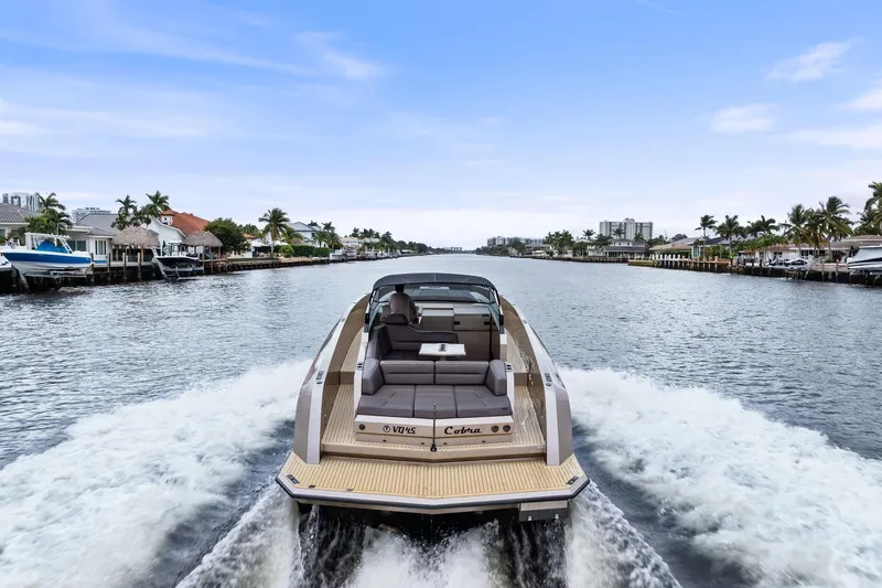Cobra Yacht Photos Pics 2022 Vanquish Yachts VQ45 cruising on a scenic waterway with waterfront homes.