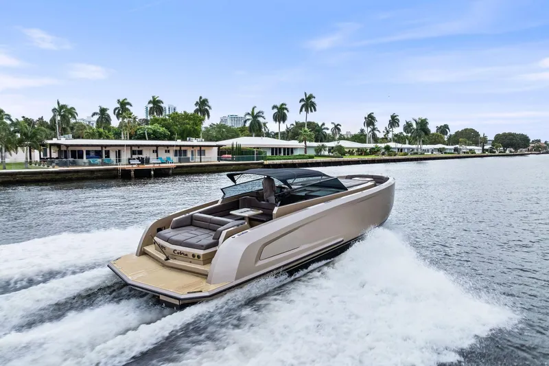 Cobra Yacht Photos Pics 2022 Vanquish Yachts VQ45 cruising on a scenic waterway with palm trees.