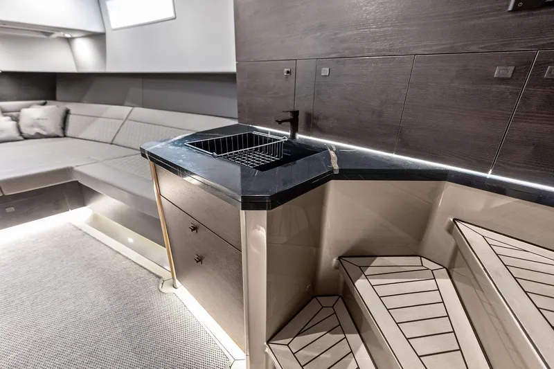 Cobra Yacht Photos Pics Luxurious interior of 2022 Vanquish Yachts VQ45 with modern kitchenette and seating area.