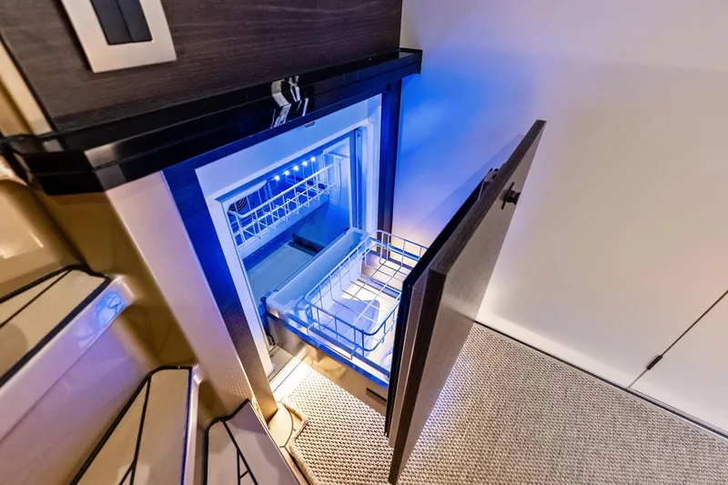 Cobra Yacht Photos Pics Open refrigerator on 2022 Vanquish Yachts VQ45, featuring modern interior lighting.