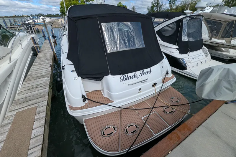 Black Pearl Yacht Photos Pics 1999 Sea Ray 380 Sundancer docked, featuring a black canopy and wooden deck.