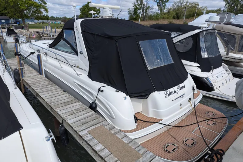 Black Pearl Yacht Photos Pics 1999 Sea Ray 380 Sundancer docked, featuring black canvas cover and spacious deck.