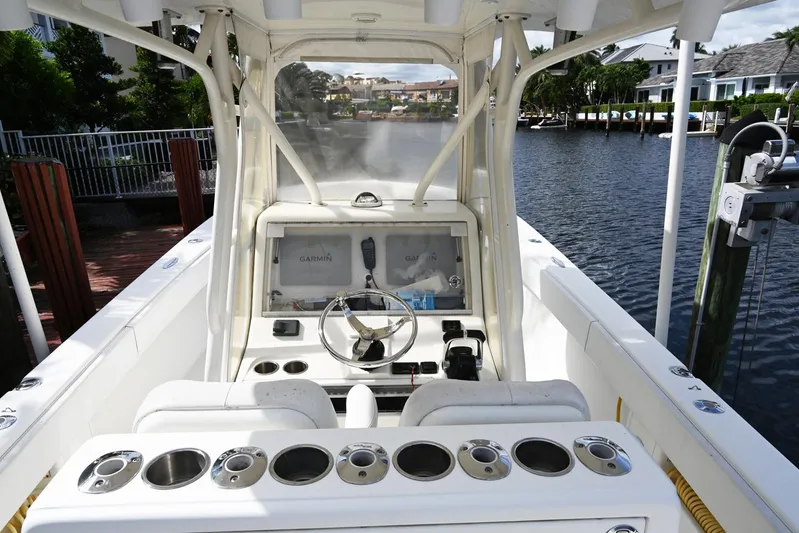  Yacht Photos Pics 2016 SeaVee 340Z boat cockpit with steering wheel, control panel, and cup holders on a calm waterway.