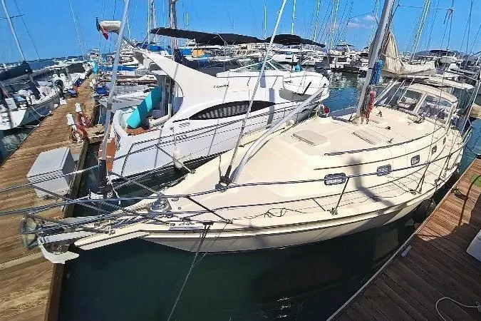  Yacht Photos Pics 1999 Island Packet 380 sailboat docked at a marina, surrounded by other boats.