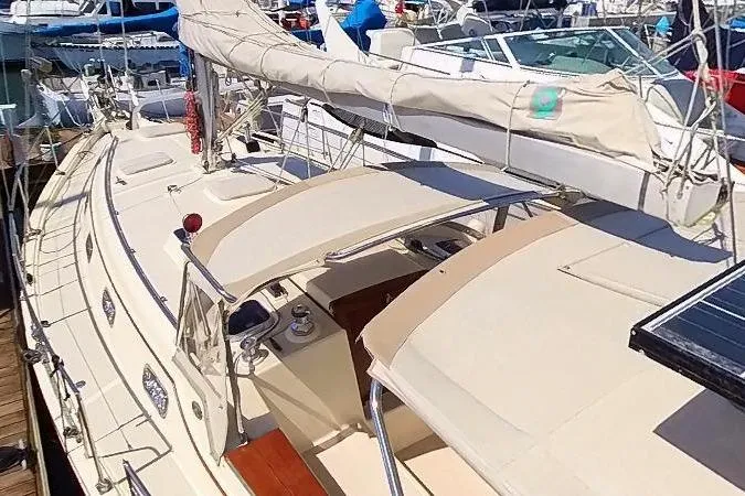  Yacht Photos Pics 1999 Island Packet 380 sailboat docked, featuring beige canopy and deck, with visible rigging.