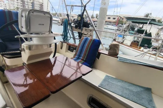  Yacht Photos Pics 1999 Island Packet 380 sailboat cockpit with wooden table and marina view.
