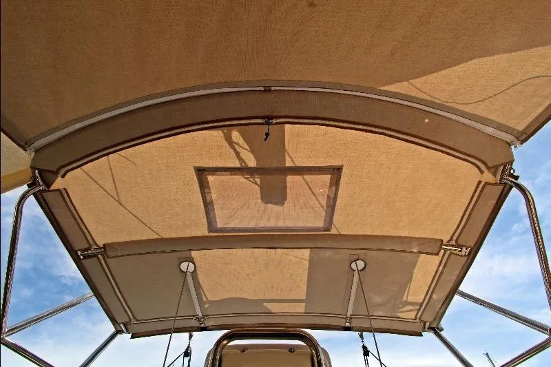  Yacht Photos Pics Bimini top of 1999 Island Packet 380 sailboat against blue sky.