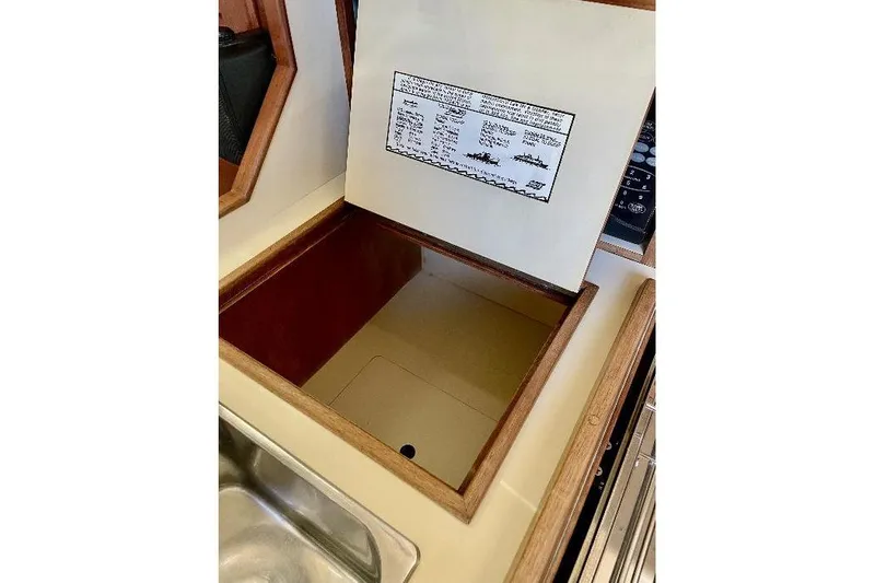  Yacht Photos Pics Interior storage compartment of 1999 Island Packet 380 sailboat, featuring wooden trim and sink.