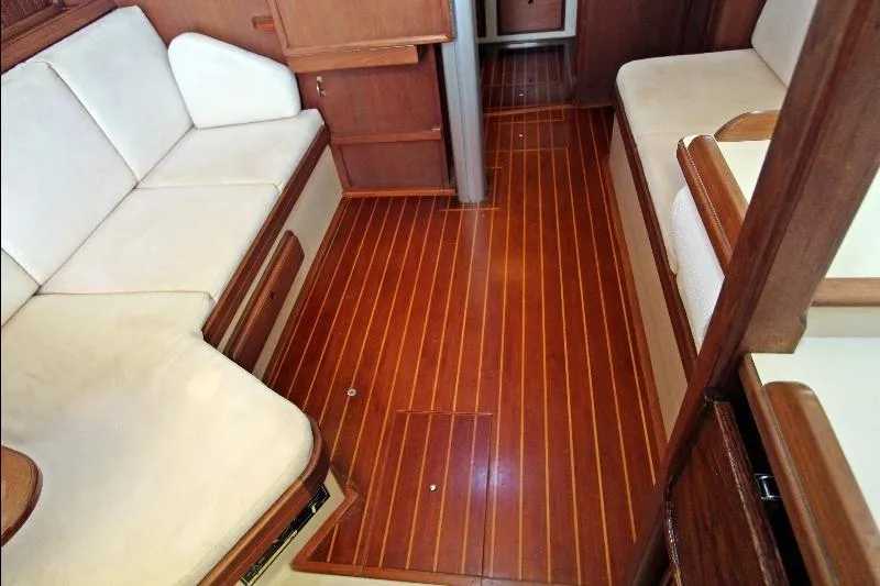  Yacht Photos Pics Interior of 1999 Island Packet 380 sailboat with wooden flooring and cushioned seating.