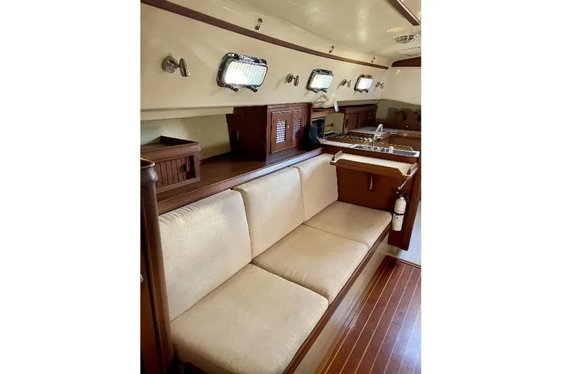  Yacht Photos Pics Interior of 1999 Island Packet 380 sailboat with wooden finish and beige seating.
