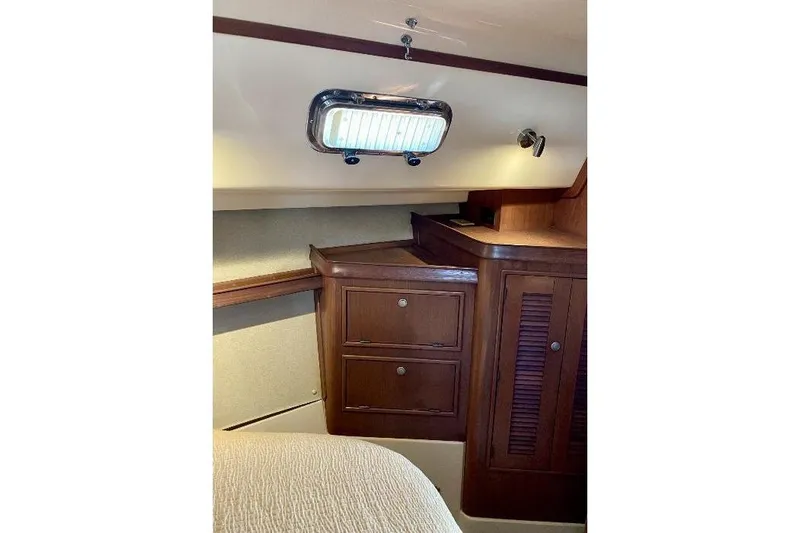  Yacht Photos Pics Interior of 1999 Island Packet 380 sailboat with wooden cabinetry and porthole window.