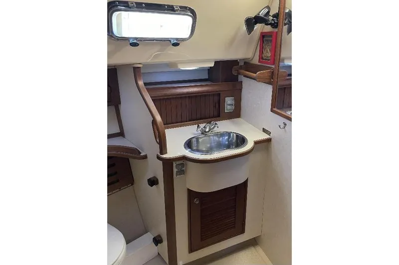  Yacht Photos Pics 1999 Island Packet 380 yacht bathroom with wooden cabinetry and stainless steel sink.