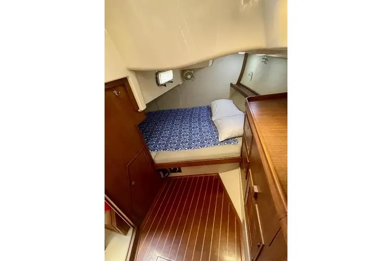  Yacht Photos Pics Cozy cabin interior of 1999 Island Packet 380 sailboat with wooden flooring and bed.