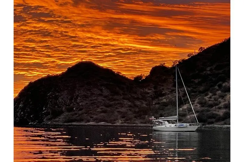  Yacht Photos Pics Sailboat Island Packet 380, 1999, anchored at sunset with vibrant orange sky.
