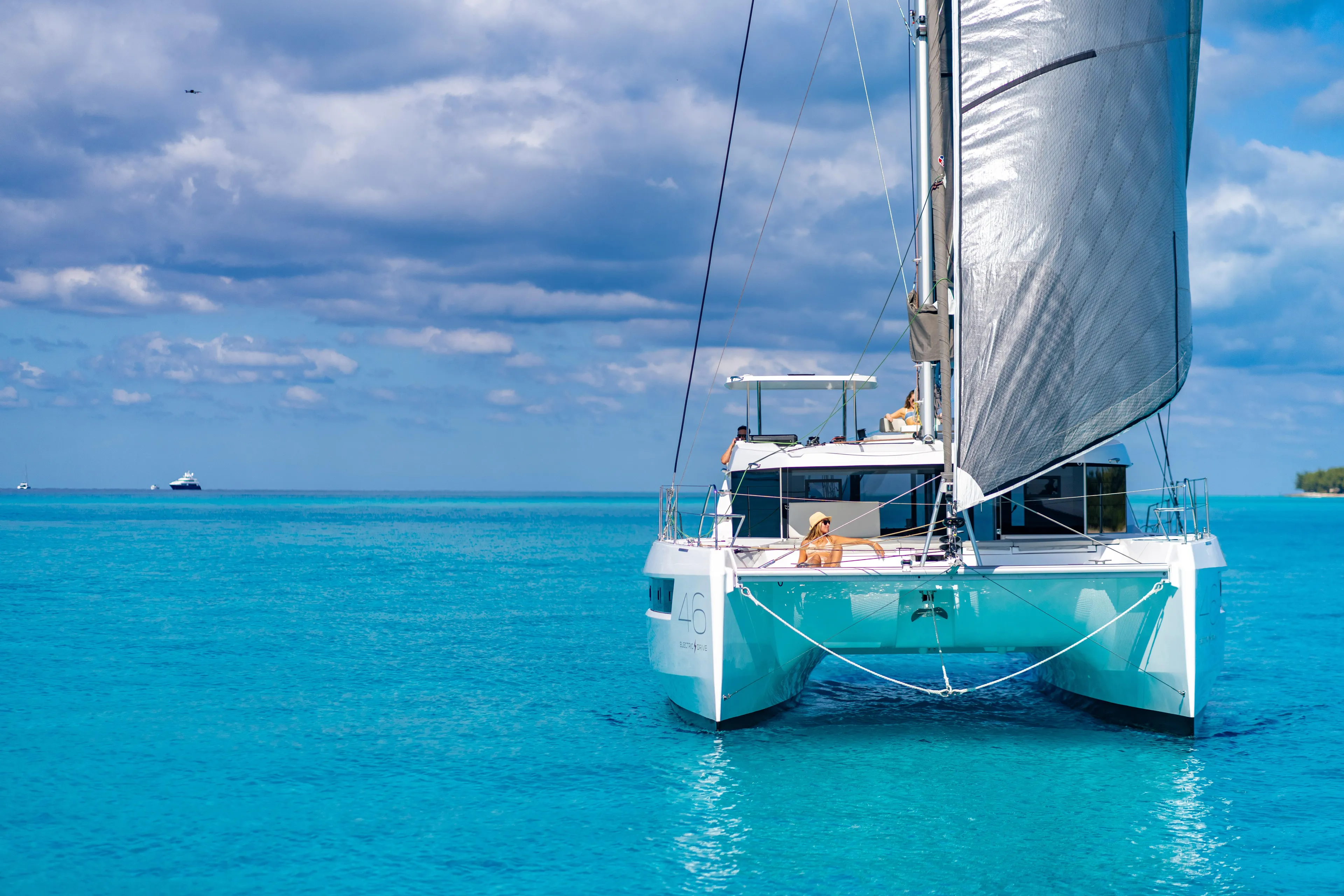 C1019 Yacht Photos Pics 2025 Leopard 46 catamaran sailing on clear blue ocean under a partly cloudy sky.