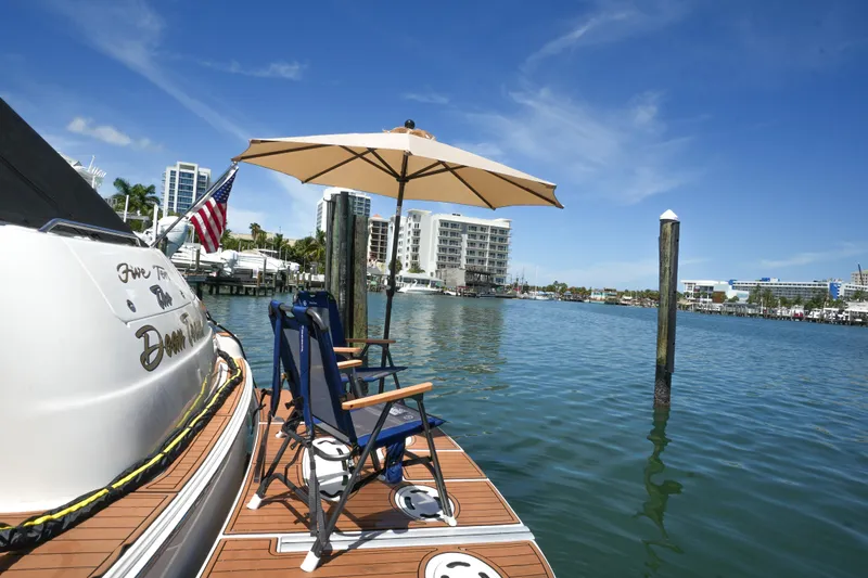  Yacht Photos Pics Sea Ray 510 Sundancer 2001 docked with chairs and umbrella, cityscape in background.