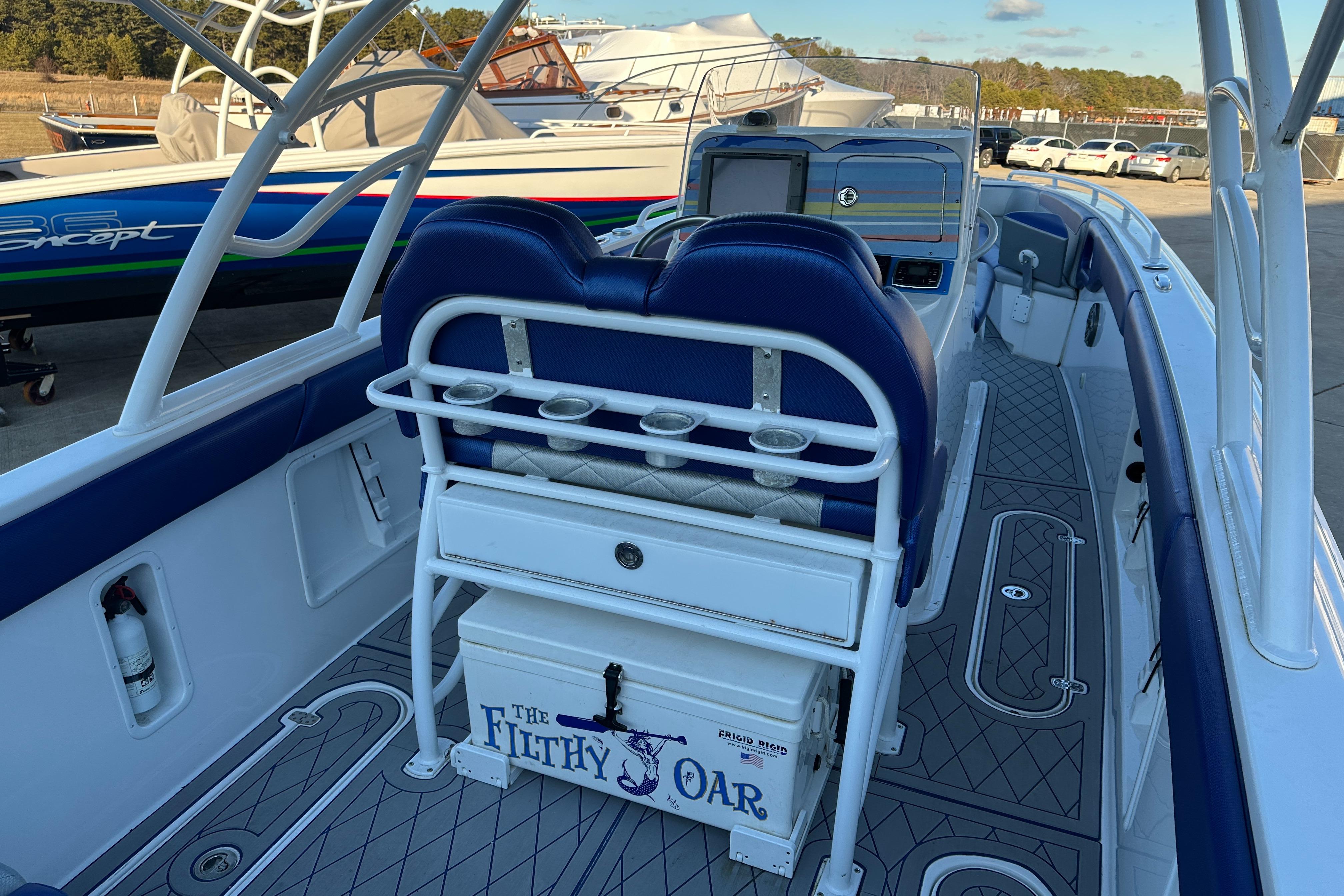 Concept 36 boat interior, 2014 model, featuring blue seating and "The Filthy Oar" cooler.