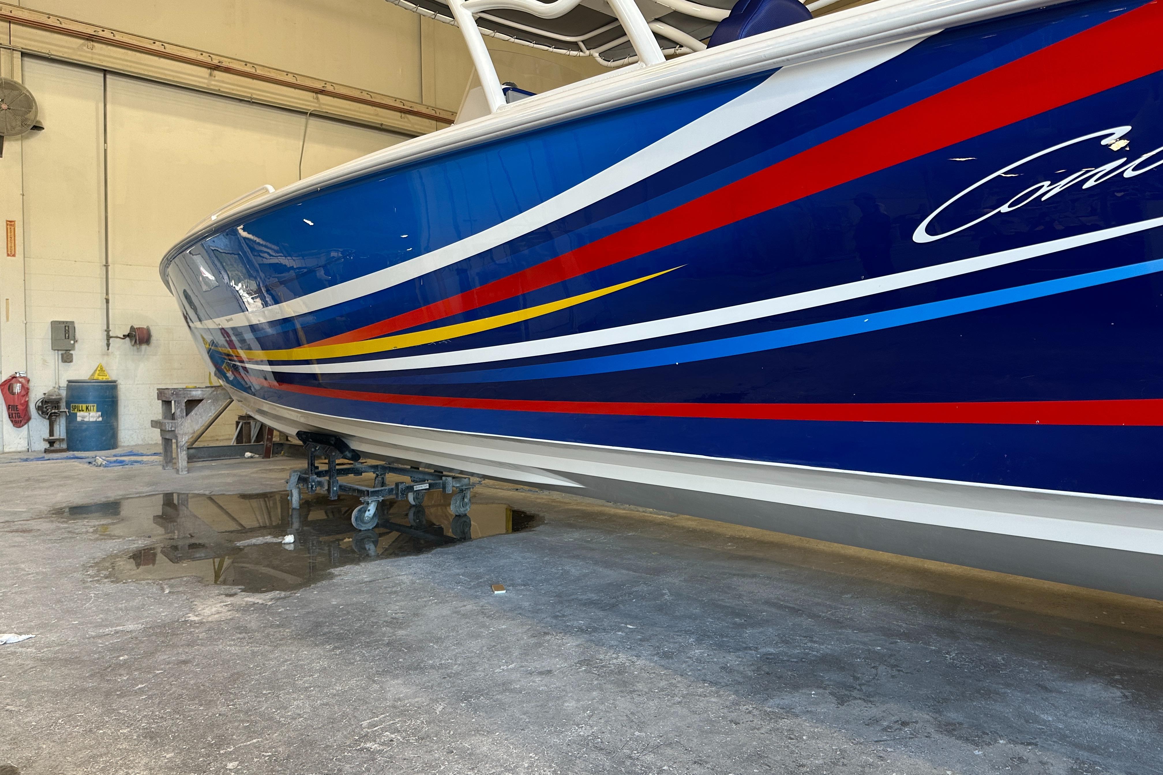Colorful 2014 Concept 36 boat with vibrant stripes in a workshop setting.