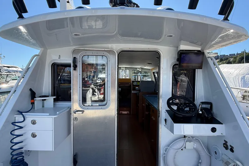 Hardy Yacht Photos Pics 2020 Coastal Craft 33 ProFish boat interior with helm, door, and equipment.