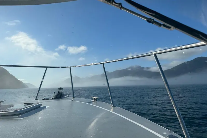 Hardy Yacht Photos Pics 2020 Coastal Craft 33 ProFish boat cruising on a misty lake with mountain views.