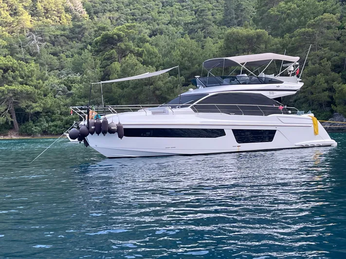 Yacht Photos Pics 2023 Azimut Fly 53 yacht anchored in serene, forested waters.