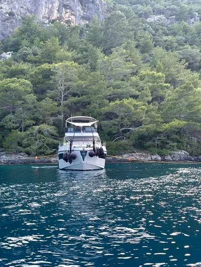  Yacht Photos Pics 2023 Azimut Fly 53 yacht anchored near lush green forest.