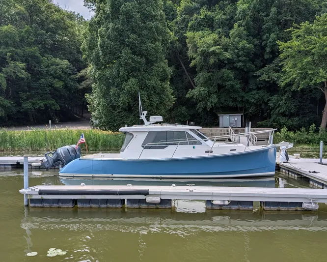  Yacht Photos Pics 2018 True North 34OE boat docked by lush green trees.
