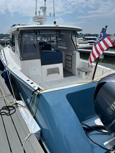  Yacht Photos Pics 2018 True North 34OE boat docked, featuring blue hull and American flag.