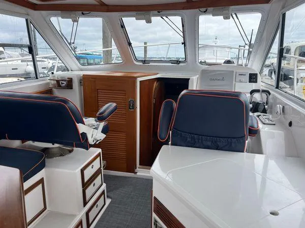 Yacht Photos Pics Interior of a 2018 True North 34OE boat with blue seating and wooden accents.