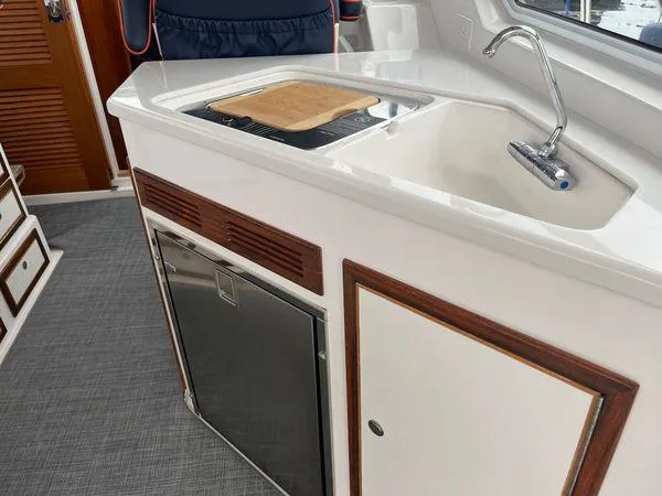  Yacht Photos Pics Compact kitchen area in a 2018 True North 34OE boat, featuring a sink and cutting board.