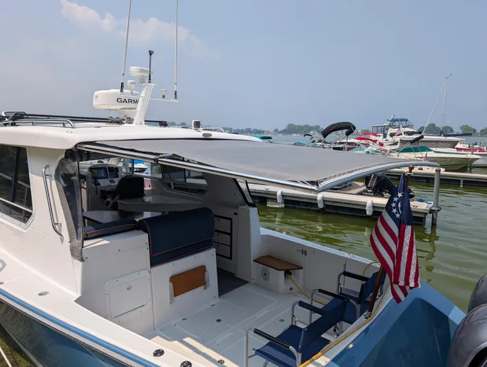  Yacht Photos Pics 2018 True North 34OE boat docked, featuring a shaded cockpit and American flag.