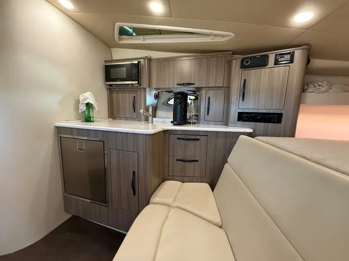 Social Distance Yacht Photos Pics 2019 Regal 35 Sport Coupe interior with kitchenette, featuring modern appliances and sleek cabinetry.