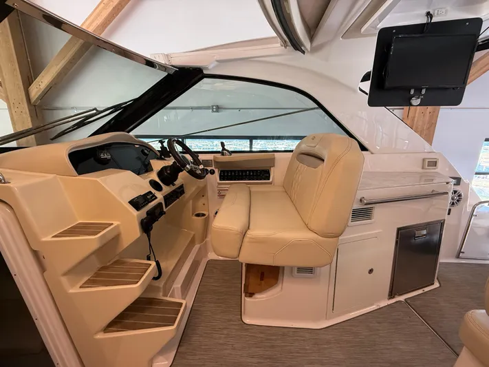 Social Distance Yacht Photos Pics 2019 Regal 35 Sport Coupe interior with helm, beige seating, and modern controls.