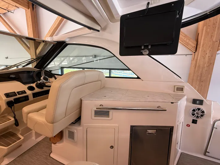 Social Distance Yacht Photos Pics 2019 Regal 35 Sport Coupe interior with helm, seating, and kitchenette.