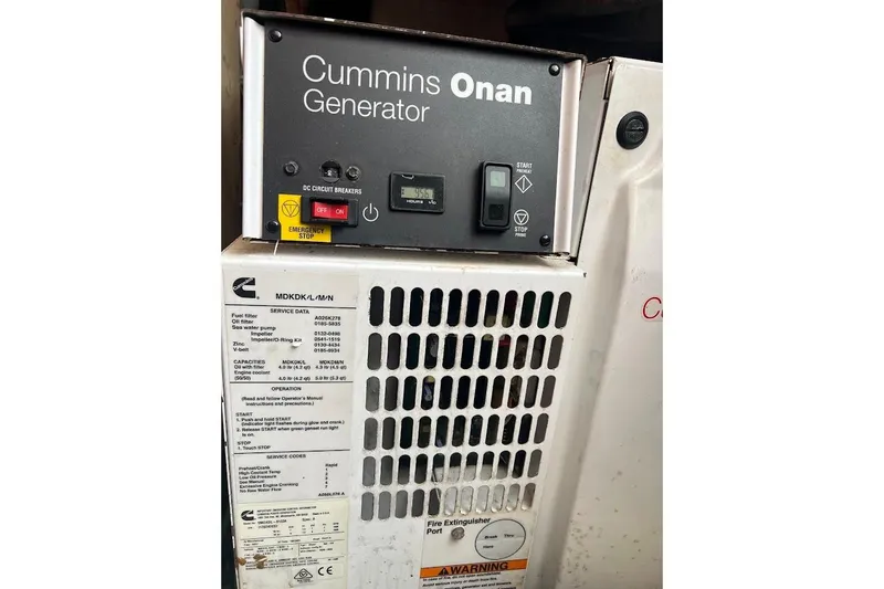 Our Trade II Yacht Photos Pics Cummins Onan generator on 1996 Ocean Yachts 48 Super Sport boat, featuring control panel and emergency stop.