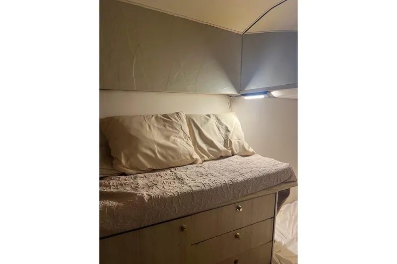 Our Trade II Yacht Photos Pics Cozy cabin bed in 1996 Ocean Yachts 48 Super Sport, featuring soft lighting and storage drawers.