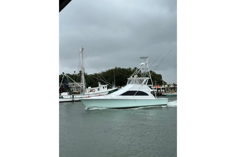 Our Trade II Yacht Photos Pics 1996 Ocean Yachts 48 Super Sport cruising on a cloudy day near a marina.
