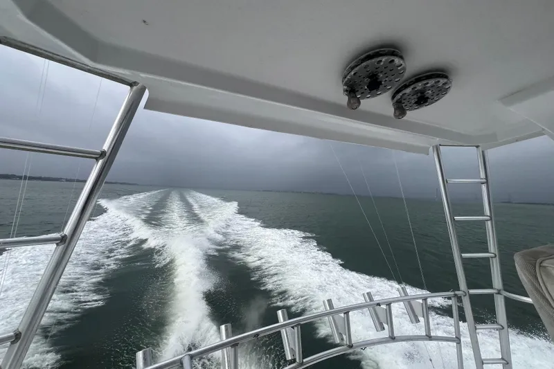 Our Trade II Yacht Photos Pics 1996 Ocean Yachts 48 Super Sport cruising, leaving a foamy wake under cloudy skies.