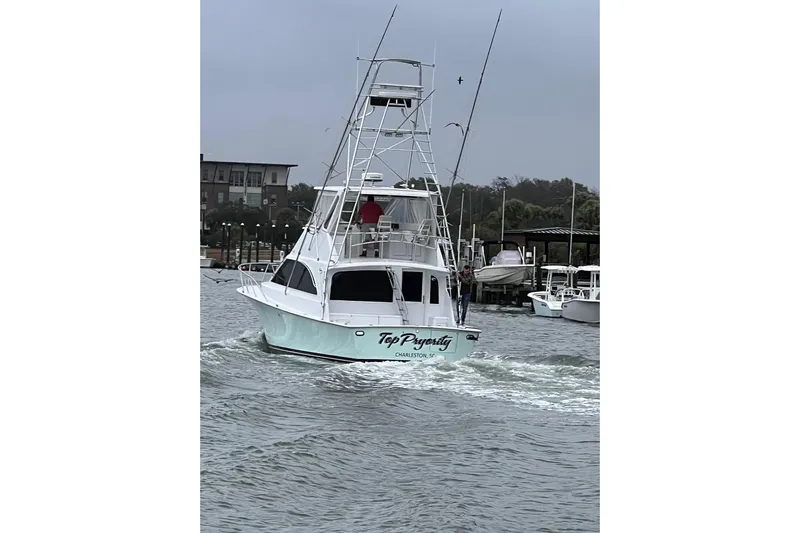 Our Trade II Yacht Photos Pics 1996 Ocean Yachts 48 Super Sport boat cruising in a marina with overcast skies.