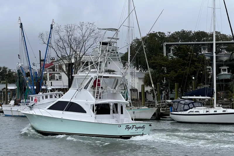 Our Trade II Yacht Photos Pics 1996 Ocean Yachts 48 Super Sport cruising in a marina, surrounded by other boats.