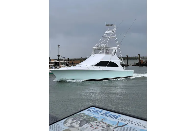 Our Trade II Yacht Photos Pics 1996 Ocean Yachts 48 Super Sport cruising near a dock under cloudy skies.