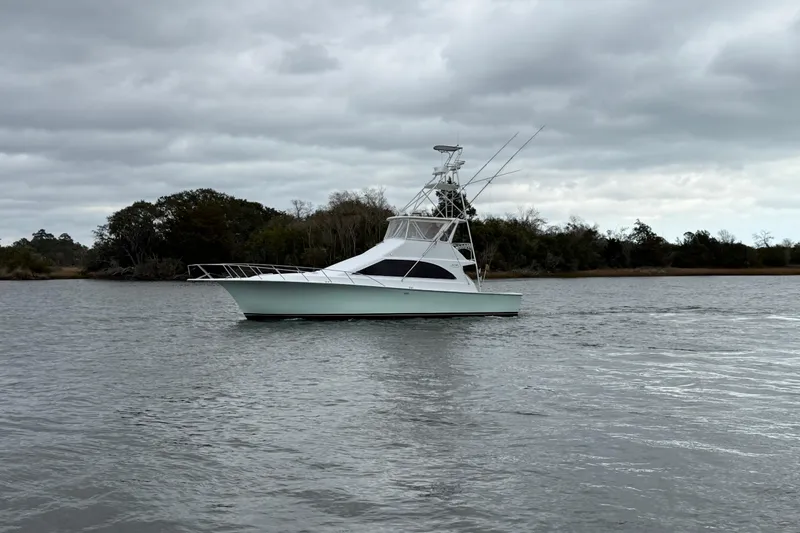 Our Trade II Yacht Photos Pics 1996 Ocean Yachts 48 Super Sport on calm waters under cloudy skies.