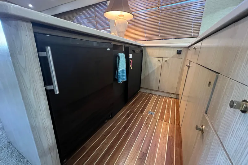 Our Trade II Yacht Photos Pics 1996 Ocean Yachts 48 Super Sport interior kitchen with wooden flooring and modern cabinetry.