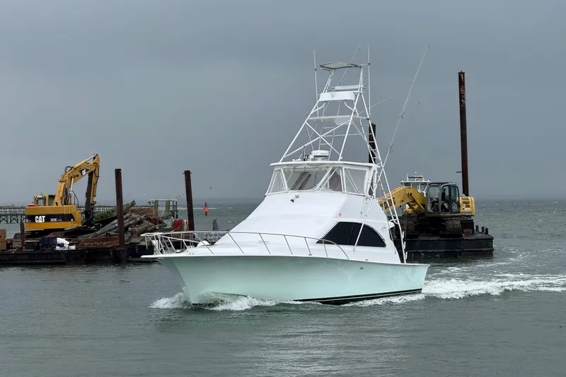 Our Trade II Yacht Photos Pics 1996 Ocean Yachts 48 Super Sport cruising near construction site in overcast weather.