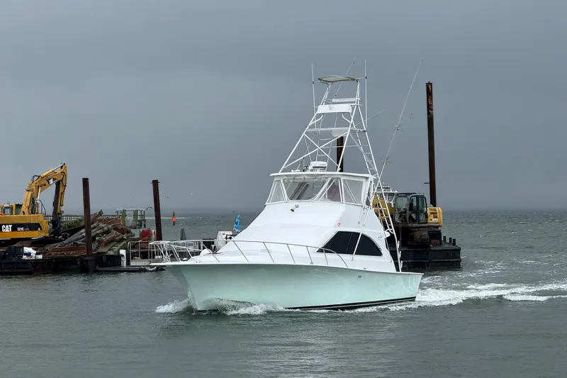 Our Trade II Yacht Photos Pics 1996 Ocean Yachts 48 Super Sport cruising near construction site on overcast day.
