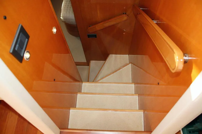  Yacht Photos Pics Staircase inside 1998 Sanlorenzo 62 yacht with wooden handrails and carpeted steps.